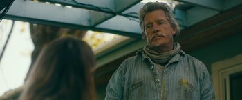 Movie still from “Acidman” (2022), directed by Alex Lehmann – An older man with a gray beard is looking at a woman; Close Up shot, Over the shoulder angle