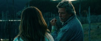 Movie still from “Acidman” (2022), directed by Alex Lehmann – A man and a woman standing next to each other; Medium shot, Over the shoulder angle