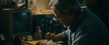 Movie still from “Acidman” (2022), directed by Alex Lehmann – An older man writing on a piece of paper; Close Up shot, High angle