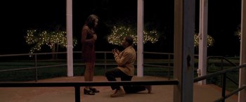 Movie still from “Acrimony” (2018), directed by Tyler Perry – A man kneeling down to propose to a woman; Wide shot, High angle