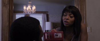 Movie still from “Acrimony” (2018), directed by Tyler Perry – A woman looking at a red box with a picture of a man; Close Up shot, Over the shoulder angle