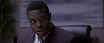 Movie still from “Acrimony” (2018), directed by Tyler Perry – A man wearing a suit and tie sitting in front of a camera; Close Up shot, Over the shoulder angle