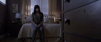 Movie still from “Acrimony” (2018), directed by Tyler Perry – A woman sitting on the edge of a bed in front of a window; Medium shot, High angle