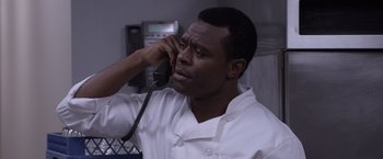 Movie still from “Acrimony” (2018), directed by Tyler Perry – A man talking on a phone while wearing a chef's outfit; Close Up shot, Over the shoulder angle