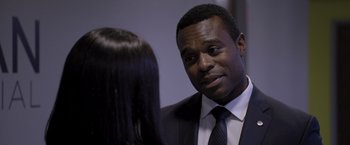 Movie still from “Acrimony” (2018), directed by Tyler Perry – A man in a business suit talking to a woman in a business suit; Close Up shot, Over the shoulder angle