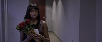 Movie still from “Acrimony” (2018), directed by Tyler Perry – A woman standing in a hallway holding a flower; Close Up shot, High angle
