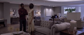 Movie still from “Acrimony” (2018), directed by Tyler Perry – Two people standing in front of a couch in a living room; Wide shot, Over the shoulder angle