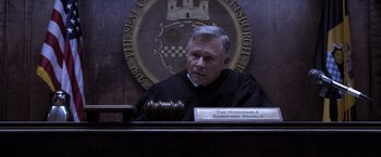 Movie still from “Acrimony” (2018), directed by Tyler Perry – A judge sitting in front of a judge's bench; Medium shot, High angle