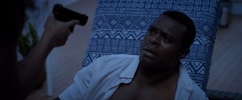 Movie still from “Acrimony” (2018), directed by Tyler Perry – A man laying in bed with a gun pointed at him; Close Up shot, High angle