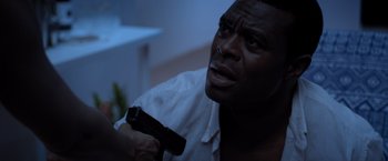 Movie still from “Acrimony” (2018), directed by Tyler Perry – A man holding a gun in his hand and looking up; Close Up shot, Over the shoulder angle