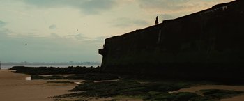 Movie still from “Across the Universe” (2007), directed by Julie Taymor – A person standing on top of a concrete structure; Extreme Wide shot, Low angle