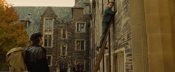 Movie still from “Across the Universe” (2007), directed by Julie Taymor – A man on a ladder in front of a building; Wide shot, Low angle