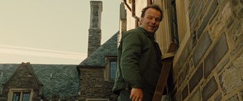 Movie still from “Across the Universe” (2007), directed by Julie Taymor – A man standing next to a brick building; Medium shot, Low angle