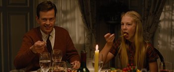 Movie still from “Across the Universe” (2007), directed by Julie Taymor – A man and a woman sitting at a dinner table; Medium shot, Over the shoulder angle