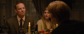 Movie still from “Across the Universe” (2007), directed by Julie Taymor – A man and a woman sitting at a dinner table; Medium shot, Over the shoulder angle
