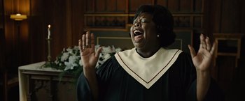 Movie still from “Across the Universe” (2007), directed by Julie Taymor – A woman in a black and white gown is singing; Close Up shot, Low angle