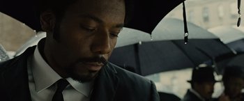 Movie still from “Across the Universe” (2007), directed by Julie Taymor – A person holding an open umbrella; Close Up shot, Low angle