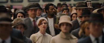 Movie still from “Across the Universe” (2007), directed by Julie Taymor – A group of people standing around each other in a crowd; Medium shot, Over the shoulder angle