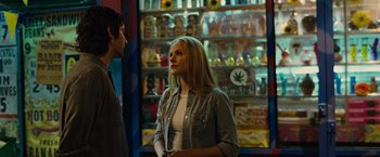 Movie still from “Across the Universe” (2007), directed by Julie Taymor – A woman standing next to a man in front of shelves; Medium shot, Over the shoulder angle