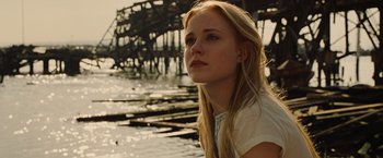 Movie still from “Across the Universe” (2007), directed by Julie Taymor – A beautiful young blond haired woman sitting on the beach; Close Up shot, Low angle