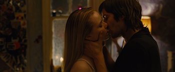 Movie still from “Across the Universe” (2007), directed by Julie Taymor – A man and a woman kissing in front of a window; Close Up shot, Low angle
