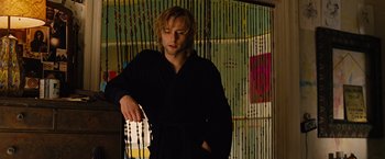 Movie still from “Across the Universe” (2007), directed by Julie Taymor – A man in a black robe is holding a candle; Medium shot, Low angle