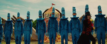 Movie still from “Across the Universe” (2007), directed by Julie Taymor – A group of people standing next to each other in blue suits; Wide shot, Low angle