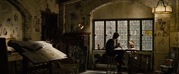 Movie still from “Across the Universe” (2007), directed by Julie Taymor – A man sitting in a chair in front of a window; Wide shot, Low angle
