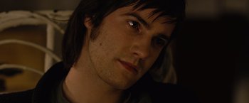 Movie still from “Across the Universe” (2007), directed by Julie Taymor – A man's face in a dark room; Close Up shot, High angle