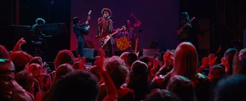 Movie still from “Across the Universe” (2007), directed by Julie Taymor – A group of people on a stage playing guitar; Wide shot, Low angle