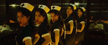 Movie still from “Across the Universe” (2007), directed by Julie Taymor – A group of women dressed in black and white uniforms; Medium shot, Low angle