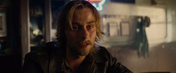 Movie still from “Across the Universe” (2007), directed by Julie Taymor – A person wearing a leather jacket; Close Up shot, Over the shoulder angle