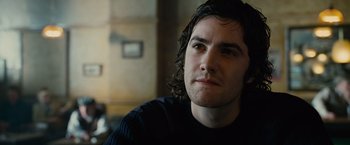 Movie still from “Across the Universe” (2007), directed by Julie Taymor – A person sitting in a room; Close Up shot, Low angle