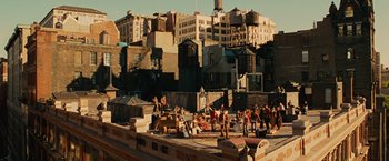 Movie still from “Across the Universe” (2007), directed by Julie Taymor – A group of people standing on top of a building; Extreme Wide shot, High angle