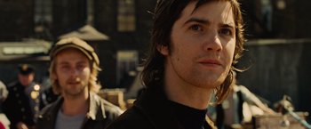 Movie still from “Across the Universe” (2007), directed by Julie Taymor – A person with long brown hair; Close Up shot, Over the shoulder angle