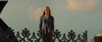 Movie still from “Across the Universe” (2007), directed by Julie Taymor – A woman standing in front of an iron fence; Medium shot, Low angle