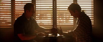 Movie still from “Act of Valor” (2012), directed by Scott Waugh – Two people sitting at a table in front of a window; Close Up shot, Over the shoulder angle