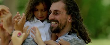 Movie still from “Act of Valor” (2012), directed by Scott Waugh – A man and a little girl smiling for the camera; Close Up shot, Over the shoulder angle