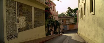 Movie still from “Act of Valor” (2012), directed by Scott Waugh – A pink building with flowers on the side of the street; Extreme Wide shot, Low angle