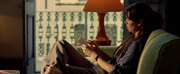 Movie still from “Act of Valor” (2012), directed by Scott Waugh – A woman sitting on a couch looking at her cell phone; Medium shot, High angle