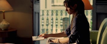 Movie still from “Act of Valor” (2012), directed by Scott Waugh – A woman sitting on a chair writing on a piece of paper; Medium shot, Over the shoulder angle