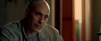 Movie still from “Act of Valor” (2012), directed by Scott Waugh – A man with a bald head looking at the camera; Close Up shot, Over the shoulder angle