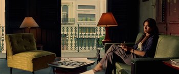 Movie still from “Act of Valor” (2012), directed by Scott Waugh – A person sitting on a couch with a lamp in front of a window; Wide shot, Low angle