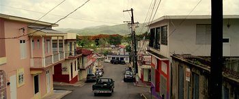Movie still from “Act of Valor” (2012), directed by Scott Waugh – Cars are driving down a street in a small town; Extreme Wide shot, High angle