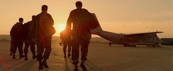 Movie still from “Act of Valor” (2012), directed by Scott Waugh – A group of soldiers walking towards an airplane at sunset; Wide shot, Low angle