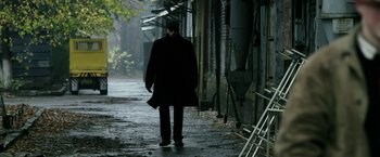 Movie still from “Act of Valor” (2012), directed by Scott Waugh – A man walking down a street in a black coat; Wide shot, Low angle