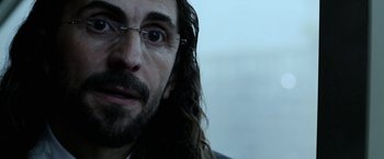 Movie still from “Act of Valor” (2012), directed by Scott Waugh – A person with long hair wearing glasses; Close Up shot, Over the shoulder angle