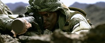 Movie still from “Act of Valor” (2012), directed by Scott Waugh – A man in a military uniform taking a picture with a camera; Extreme Close Up shot, Low angle