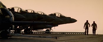 Movie still from “Act of Valor” (2012), directed by Scott Waugh – A group of fighter jets sitting on top of an airport runway; Wide shot, Low angle