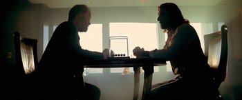 Movie still from “Act of Valor” (2012), directed by Scott Waugh – Two men sitting at a table playing a board game; Medium shot, Low angle